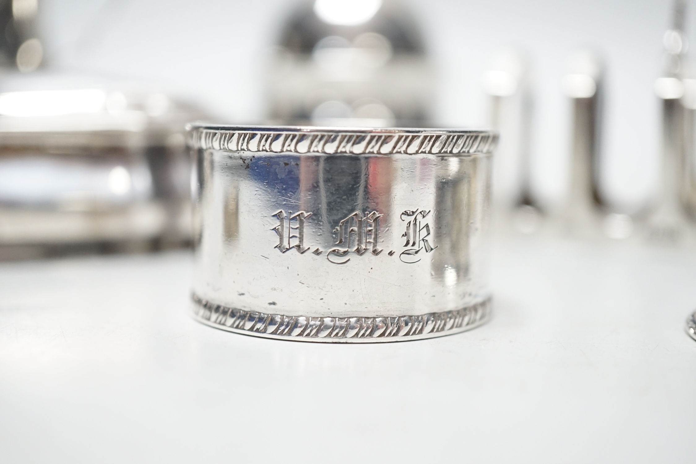 A late Victorian shaped oval silver trinket box, Birmingham, 1898, 99mm, a hexagonal silver pill box, a pair of silver toast racks and four silver serviette rings, a silver domed topped inkwell and a miniature silver two